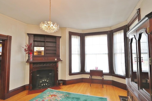 living area featuring an inviting chandelier, wood finished floors, visible vents, and baseboards