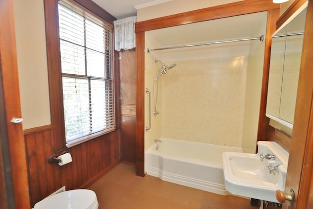 bathroom featuring a wainscoted wall, a sink, toilet, wood walls, and shower / bath combination