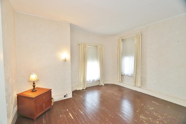 unfurnished room with baseboards and hardwood / wood-style flooring