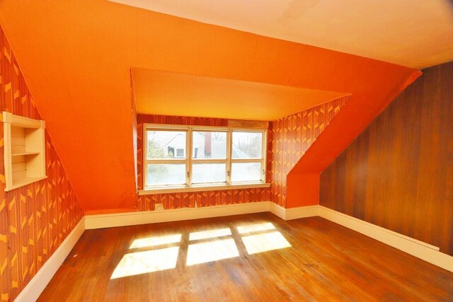 bonus room with wood finished floors and baseboards