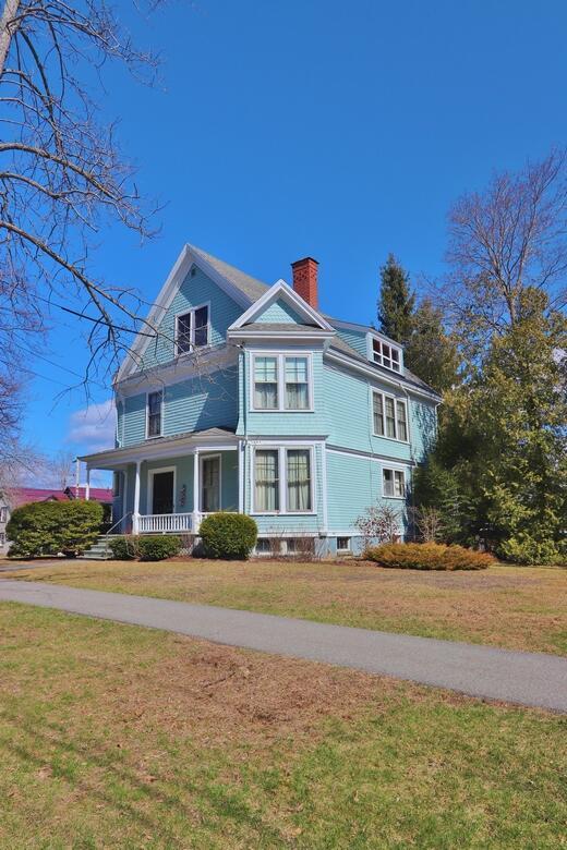exterior space with a yard, a chimney, and covered porch