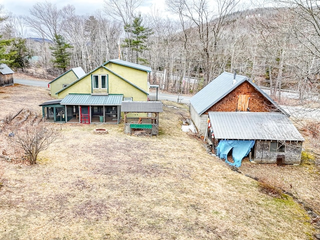 rear view of property featuring metal roof, a fire pit, and a mountain view