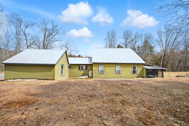 exterior space with a chimney and metal roof