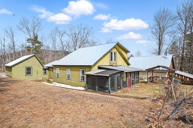 rear view of property with a sunroom and metal roof