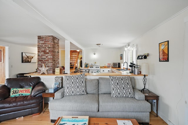 living room featuring a toaster, ornate columns, and wood finished floors