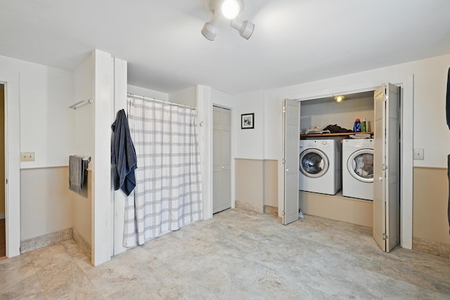 interior space with washer and clothes dryer, a shower with shower curtain, and ceiling fan