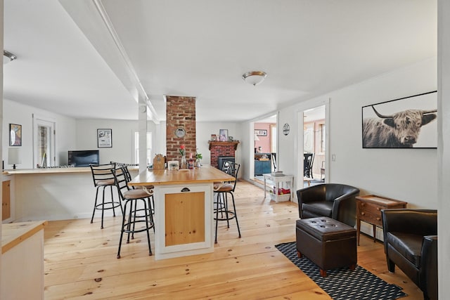 interior space featuring a breakfast bar, light wood-style floors, and open floor plan
