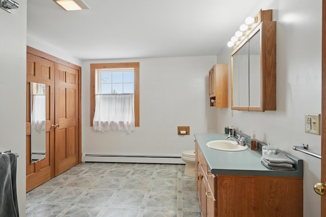 bathroom with vanity, toilet, and baseboard heating
