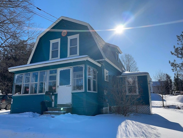 24 Albert St, Milo, ME 04463 - view of front facade with a gambrel roof and a sunroom