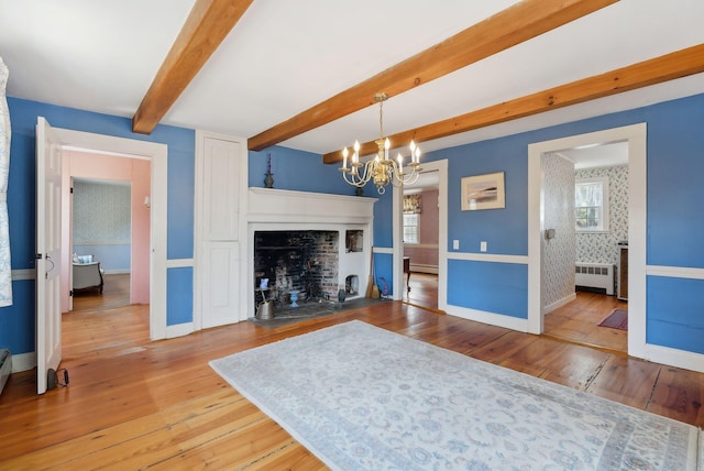 117 Youngs Ridge Rd, Acton, ME 04001 - living area with radiator, beamed ceiling, a chandelier, wood-type flooring, and baseboards