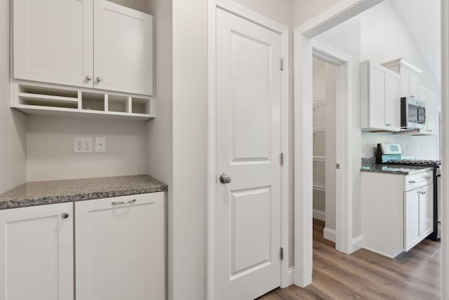 79 Colins Meadow Ln, Alfred, ME 04002 - kitchen featuring stainless steel appliances, wood finished floors, white cabinetry, dark stone countertops, and baseboards