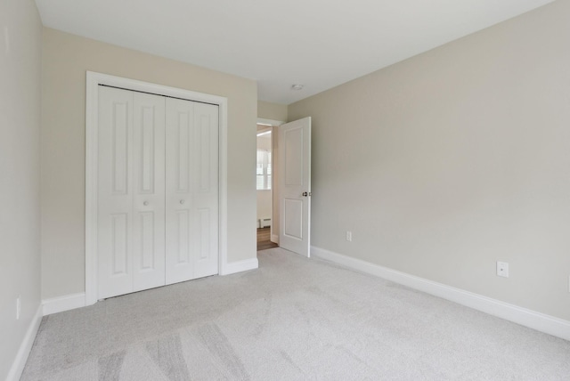 79 Colins Meadow Ln, Alfred, ME 04002 - unfurnished bedroom featuring light carpet, a closet, a baseboard heating unit, and baseboards
