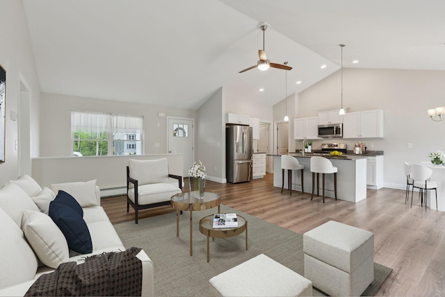 79 Colins Meadow Ln, Alfred, ME 04002 - living area with high vaulted ceiling, light wood-style flooring, baseboard heating, ceiling fan, and baseboards