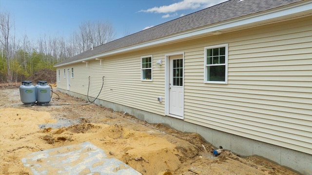 view of side of property with roof with shingles