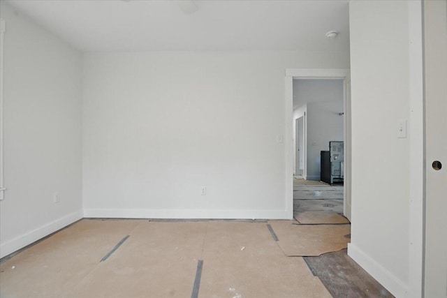 unfurnished room with baseboards