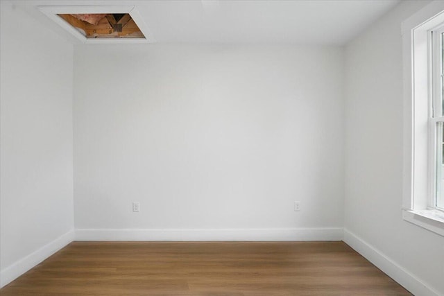 empty room featuring light wood-type flooring and baseboards