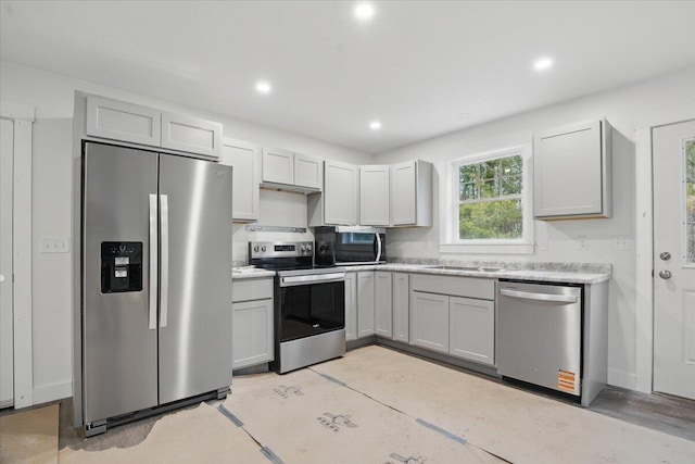 kitchen featuring a sink, light countertops, recessed lighting, and stainless steel appliances