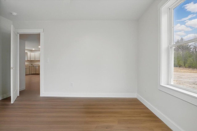 unfurnished room featuring baseboards and wood finished floors