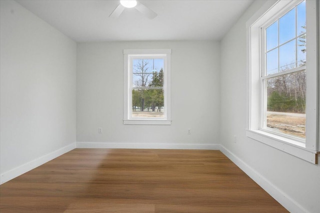 unfurnished room with baseboards, wood finished floors, and ceiling fan