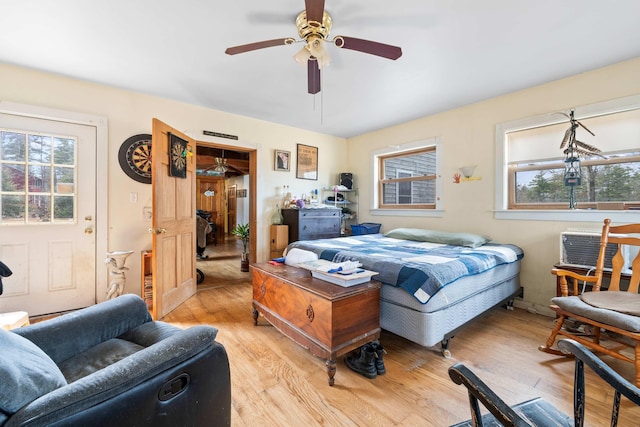 bedroom featuring light wood-type flooring, ceiling fan, and multiple windows