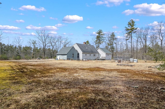 view of side of property with fence and a chimney