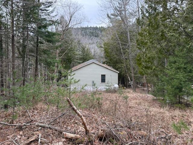 view of side of home featuring a wooded view