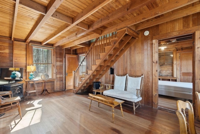 34 Jordan Shore Dr, Poland, ME 04274 - unfurnished room featuring wood walls, a wood stove, beam ceiling, wood ceiling, and stairs