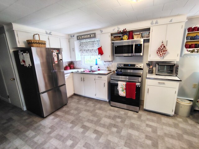 90 Whig St, Winterport, ME 04496 - kitchen featuring stainless steel appliances, light countertops, white cabinetry, and a sink