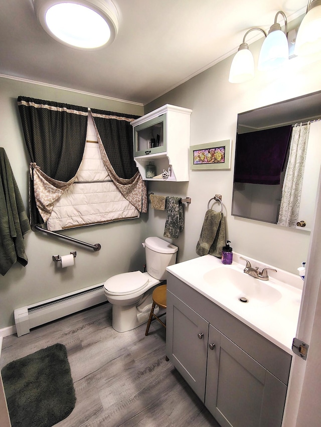 90 Whig St, Winterport, ME 04496 - bathroom with baseboard heating, wood finished floors, toilet, vanity, and ornamental molding