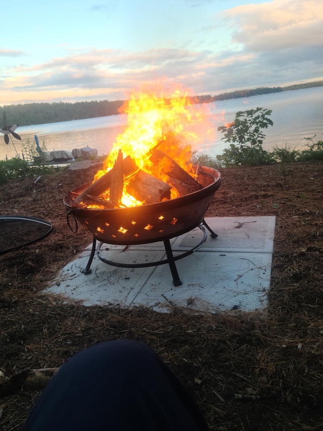 view of community with a water view and an outdoor fire pit