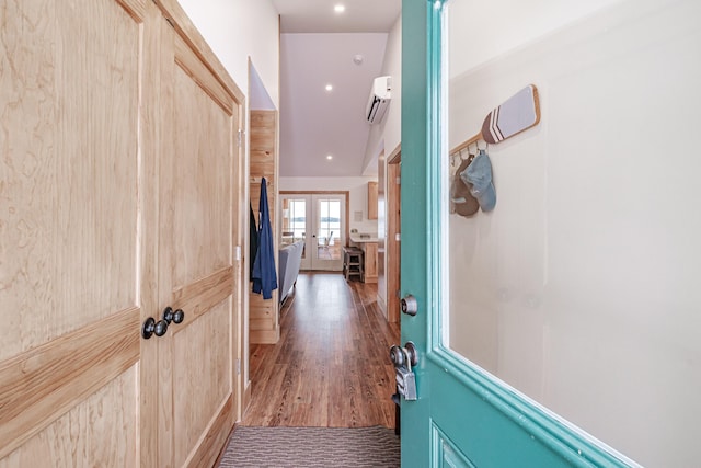 interior space with french doors, wood finished floors, and a wall mounted air conditioner