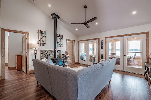 living room with a wood stove, a ceiling fan, french doors, and dark wood-style floors