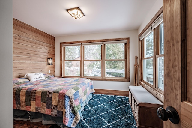 bedroom with wood finished floors and wood walls