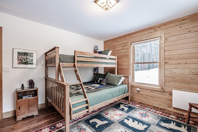 bedroom featuring wood finished floors and wood walls