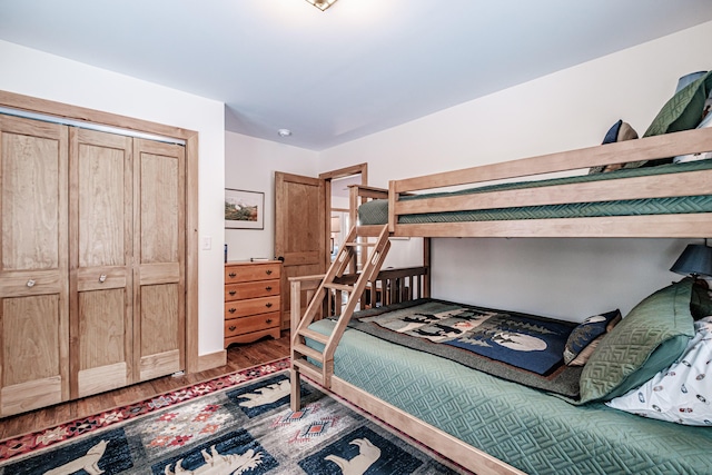 bedroom with wood finished floors and a closet
