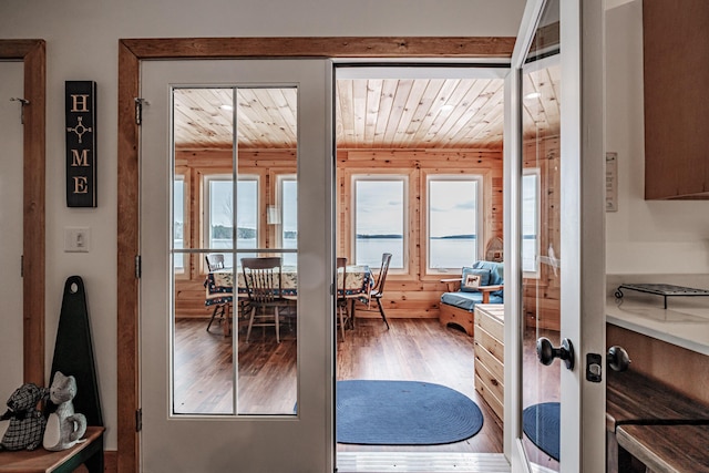 doorway with wood ceiling, plenty of natural light, and wood finished floors