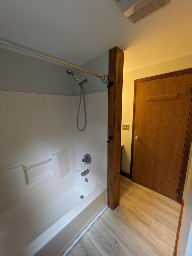 full bath with wood finished floors, visible vents, and bathtub / shower combination