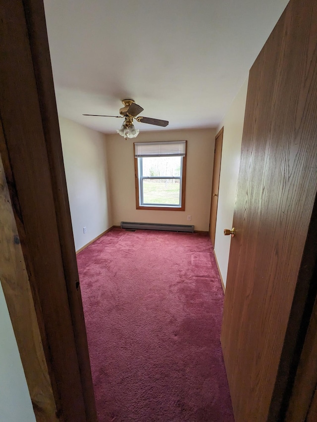 empty room featuring a ceiling fan, baseboard heating, carpet floors, and baseboards