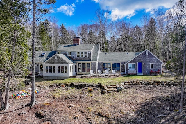 back of property featuring a sunroom, a patio, and a chimney