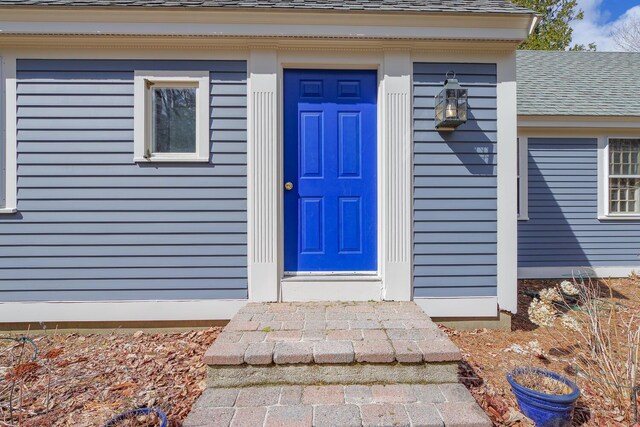 entrance to property with roof with shingles