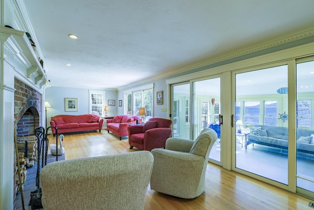 living room featuring ornamental molding, a brick fireplace, wood finished floors, and recessed lighting