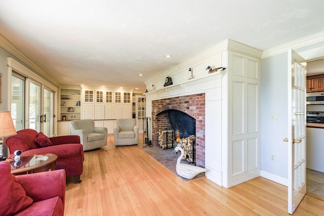 living room featuring light wood-style flooring, a fireplace, and crown molding