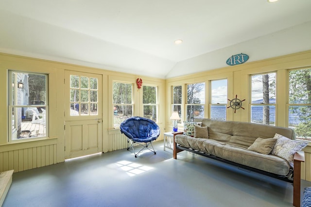sunroom with a decorative wall, vaulted ceiling, a water view, and a healthy amount of sunlight