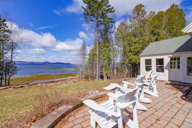 view of patio / terrace featuring a water and mountain view