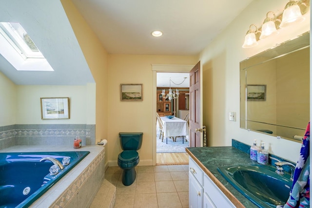 bathroom featuring tile patterned floors, a chandelier, a skylight, a garden tub, and vanity
