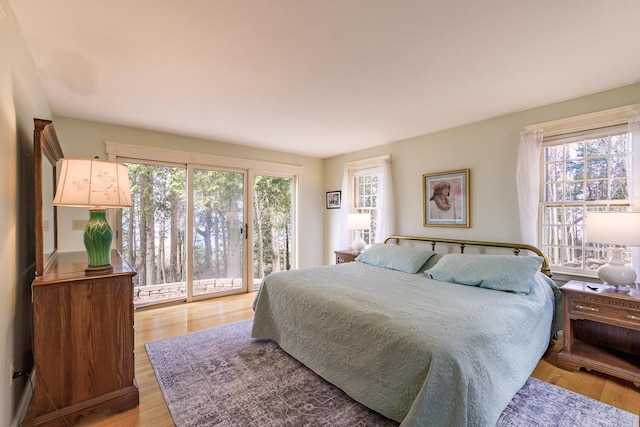 bedroom featuring access to outside and light wood finished floors