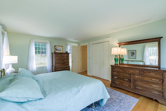 bedroom with light wood finished floors and a closet