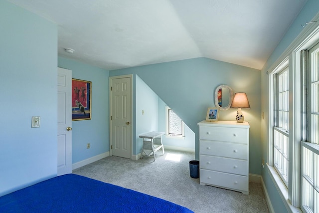 carpeted bedroom with lofted ceiling, multiple windows, and baseboards