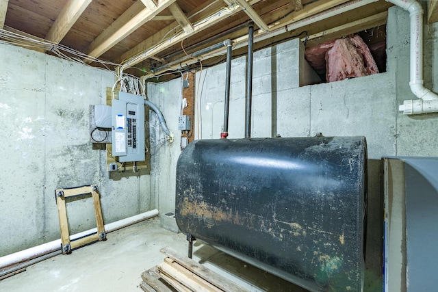unfinished basement featuring electric panel and heating fuel