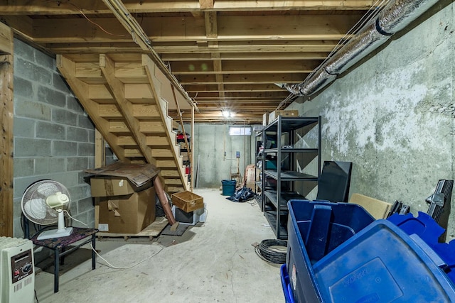 unfinished basement with heating unit and stairs